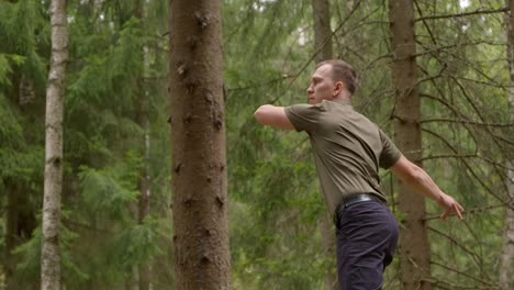 Disc-Golfer-Wirft-Rückhandwurf-In-Dichtem-Wald---Zeitlupe,-Breiter,-Mittlerer-Schuss