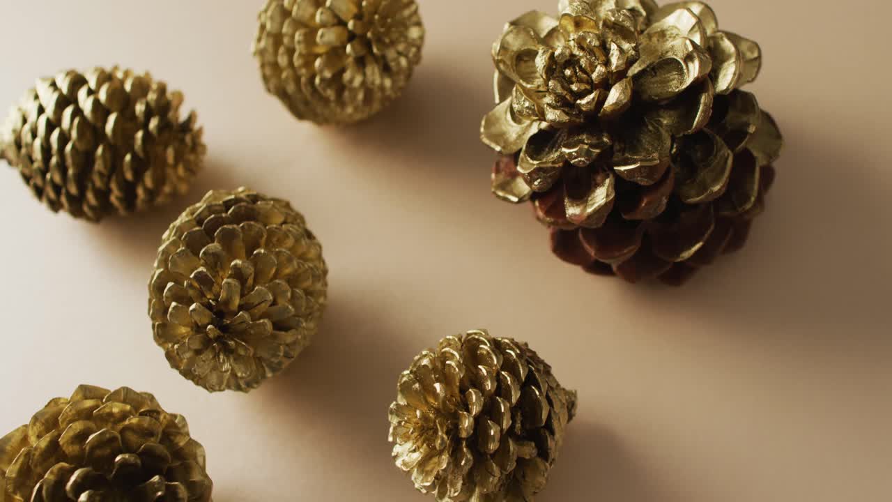 video de conas de pino acostadas en una superficie beige