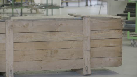 handheld footage of a forklift placing a large wooden box in an industrial setting, everything in focus