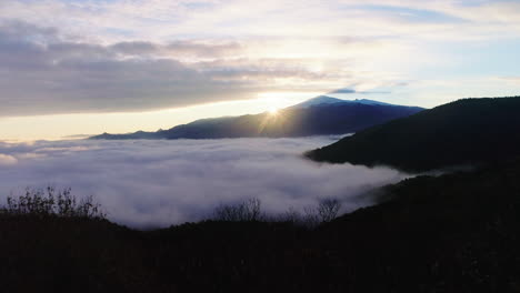 über-Die-Bäume-Fliegen,-Um-Die-Wolken-Und-Den-Sonnenaufgang-Hinter-Dem-Berg-Zu-Zeigen