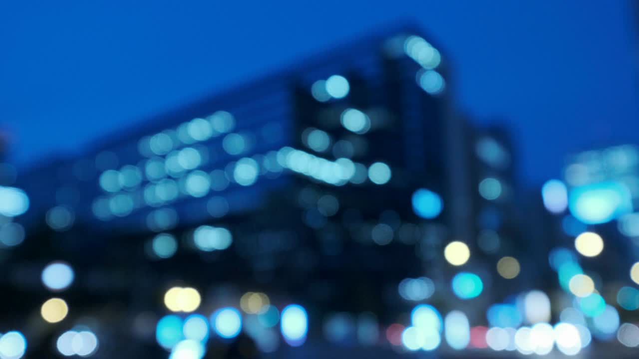 4k tono fresco vídeo desenfocado de vista nocturna urbana con transporte y transeúntes