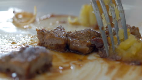 eating a dish with meat and potatoes