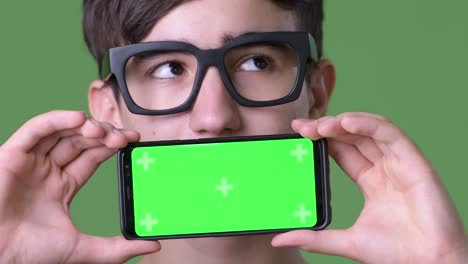 young handsome iranian teenage boy against green background