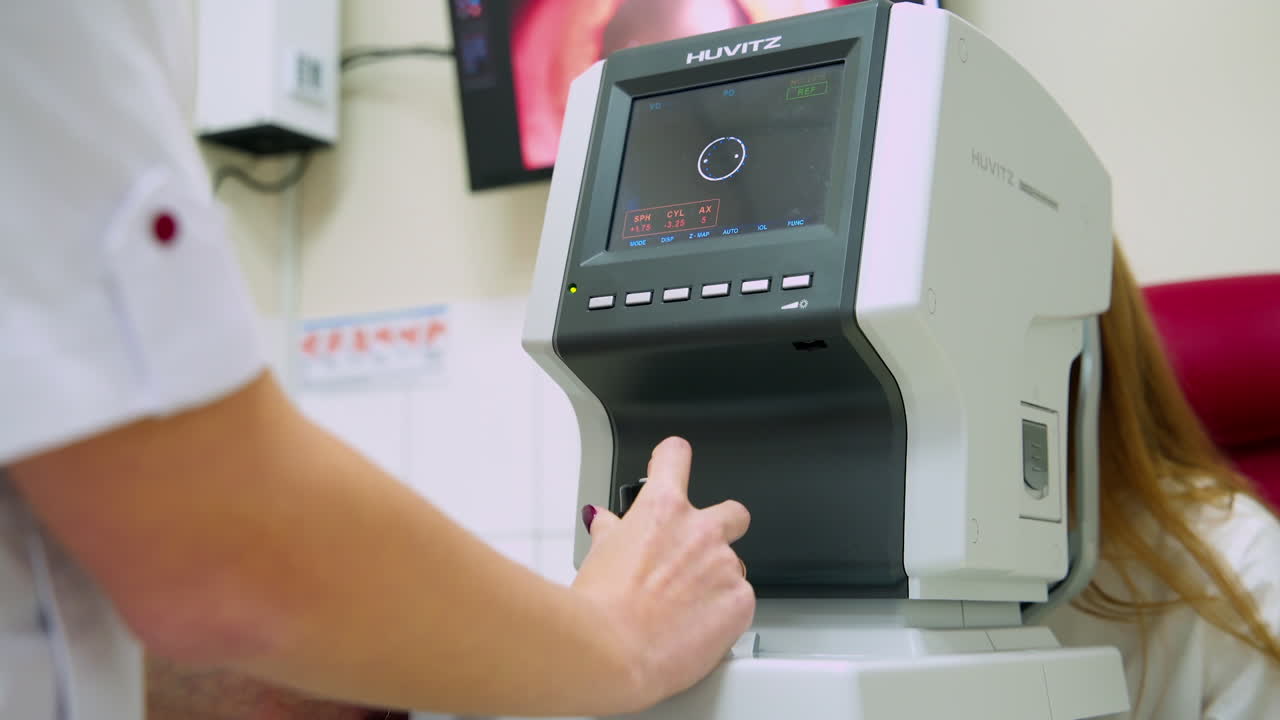 Female ophthalmologist using apparatus. Close up of woman checking eyesight on autorefractor