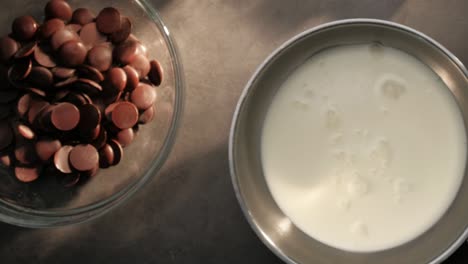 topview of dark milky chocolate and cream, hand placing a pan