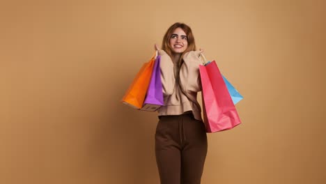 stylish female shopaholic with colorful paper bags in studio