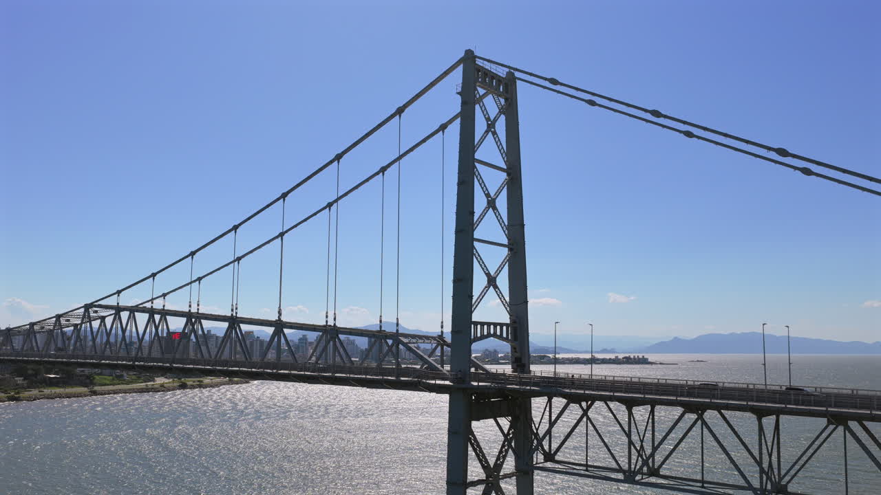 Aerial view of traffic crossing Hercilio Luz Bridge in Florianopolis, Brazil with vehicles over water and city