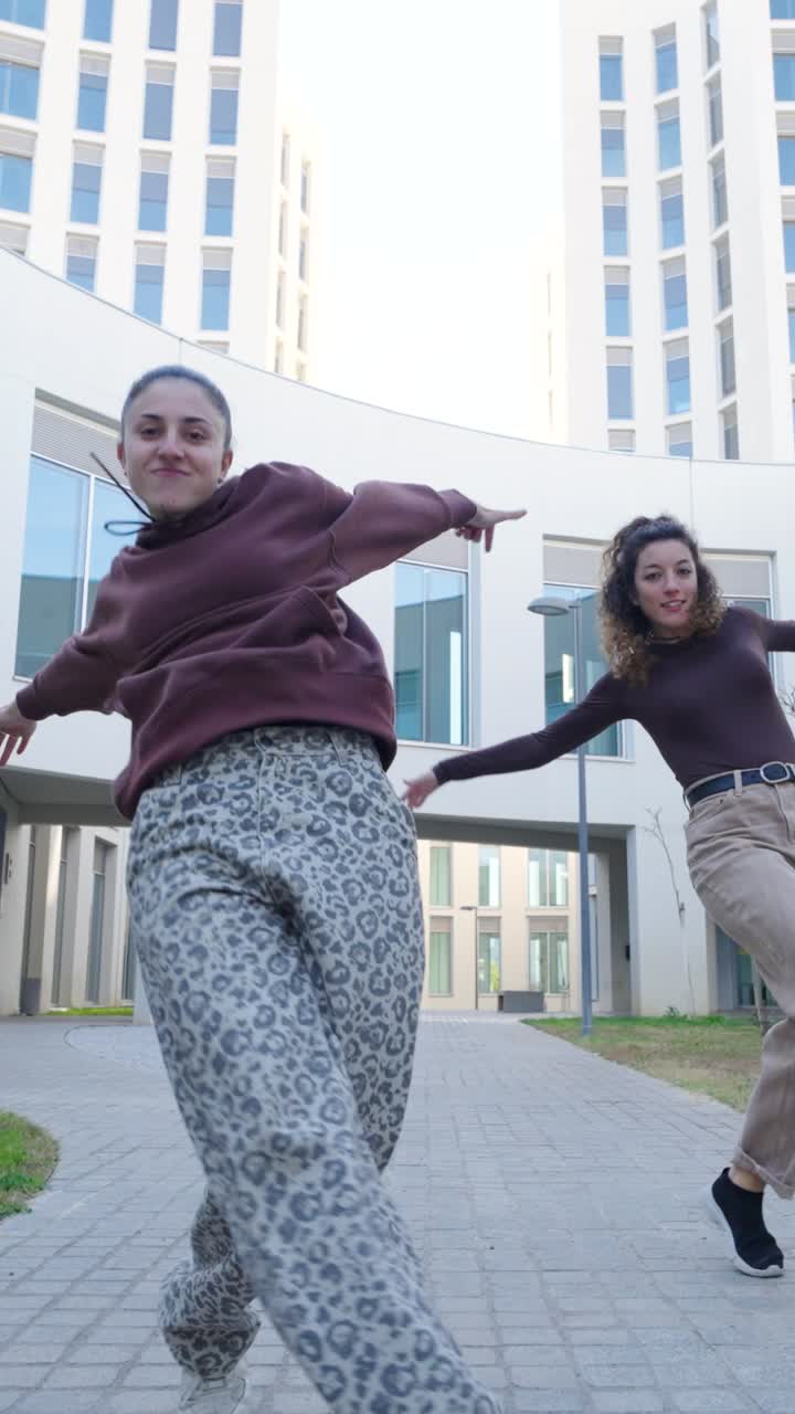 Two energetic dancers performing choreography outdoors