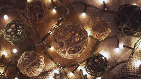 close-up christmas garland and handmade balls on a playd with golden lights. christmas concept. home decor