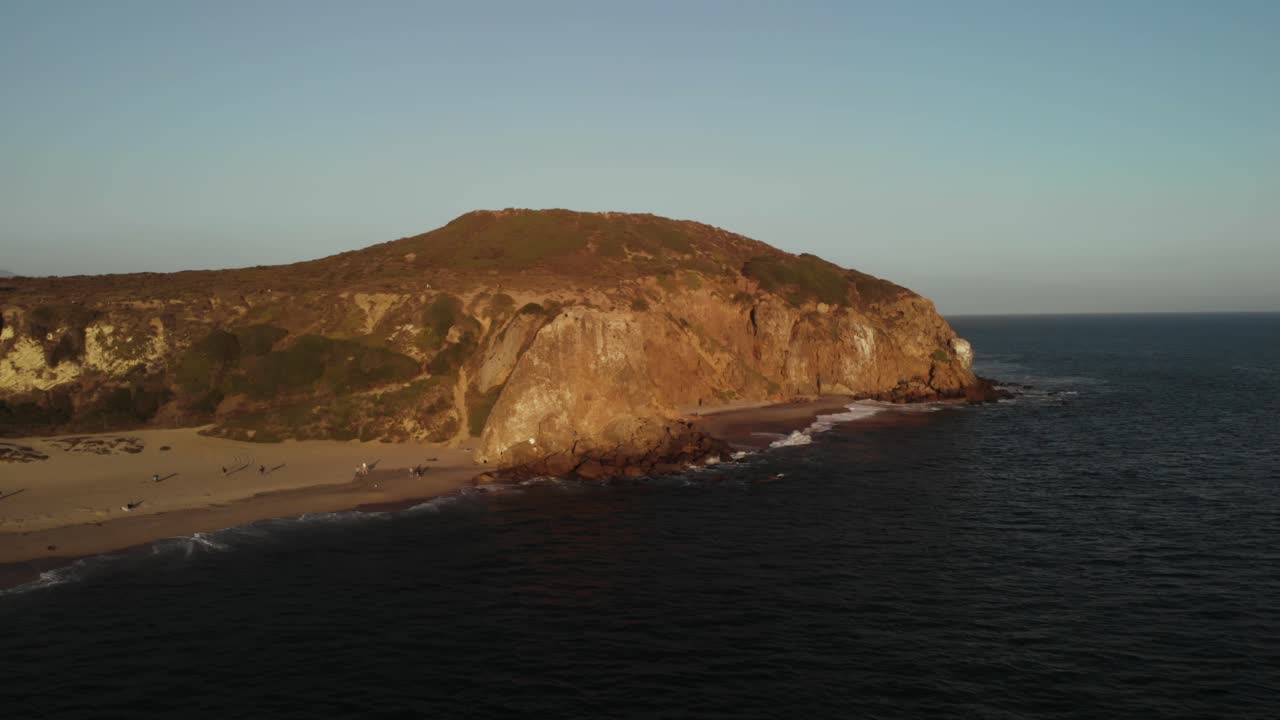 una toma aérea de los acantilados de point dume en malibú, california, por la noche mientras se pone el vibrante sol.