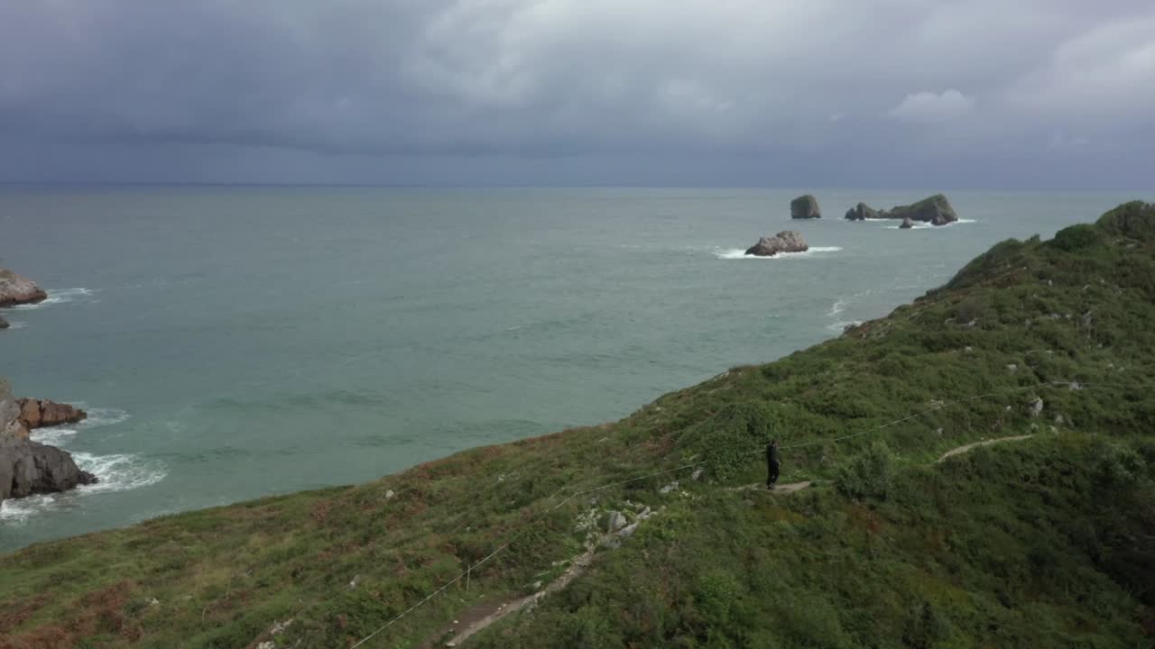 등산객은 바다를 배경으로 절벽 길을 걷는다