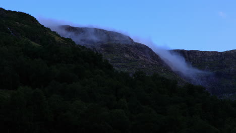 Clouds-rolling-over-mountain-and-hillside-during-early-morning