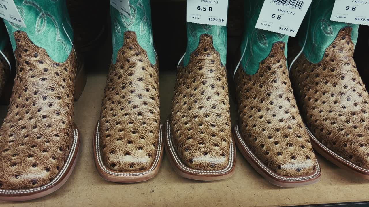 Close up of exotic ostrich leather cowboy boots with turquoise uppers on display in a western store