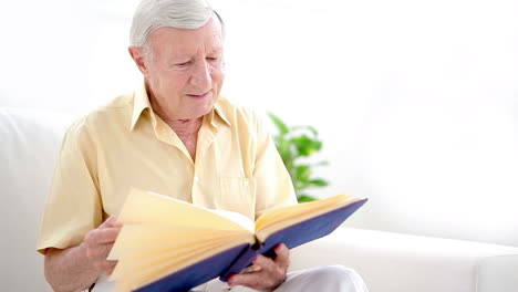 old man looking through photo album