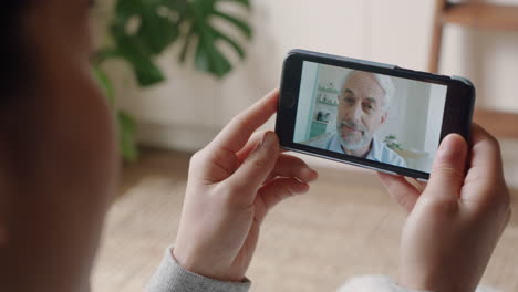 young woman having video chat using smartphone chatting to grandfather enjoying conversation sharing lifestyle communicating with mobile phone at home