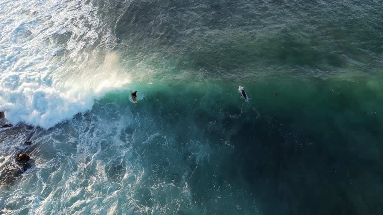 surfista atlético montando una fuerte ola cerca de sus amigos en grace town, australia occidental
