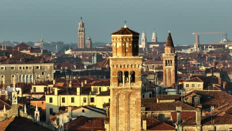 high rise structures of bell towers during sunrise in venice, italy