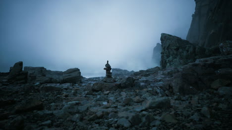 tranquil stone stack on rocky shore amid foggy atmosphere in nature