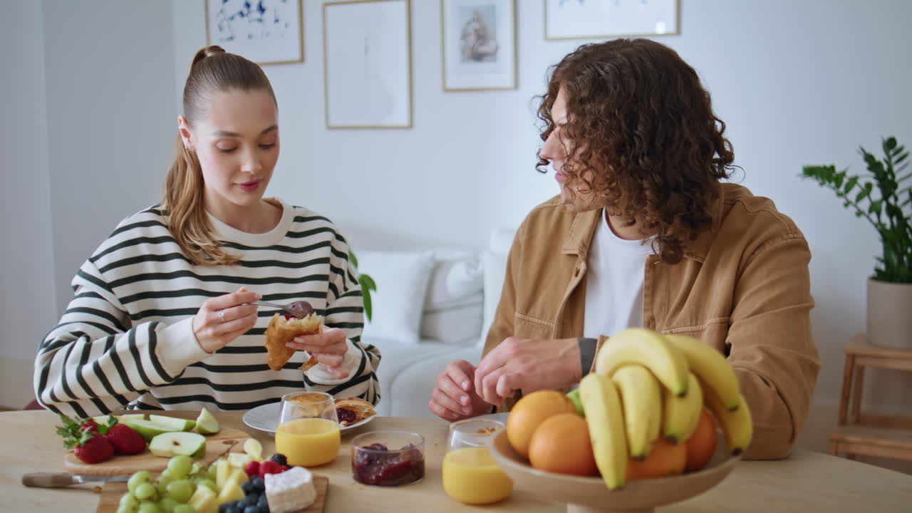 Coppia romantica gusta la colazione insieme in una cucina moderna. Uomo e donna sorridenti