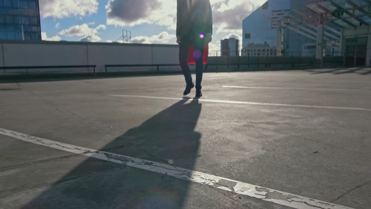 바람에 불어오는 은 케이프를 입은 사업가 슈퍼맨은 날을 구할 준비가 된 초고층 건물의 지붕을 고 있습니다.