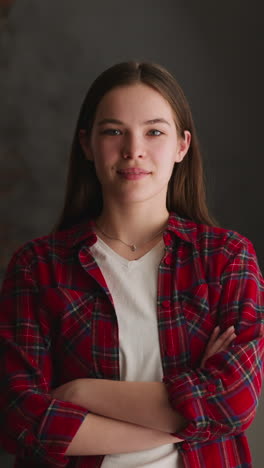 positive chestnut haired lady with crossed arms stands near window in apartment zoom in slow motion. domestic lifestyle and casual clothes style