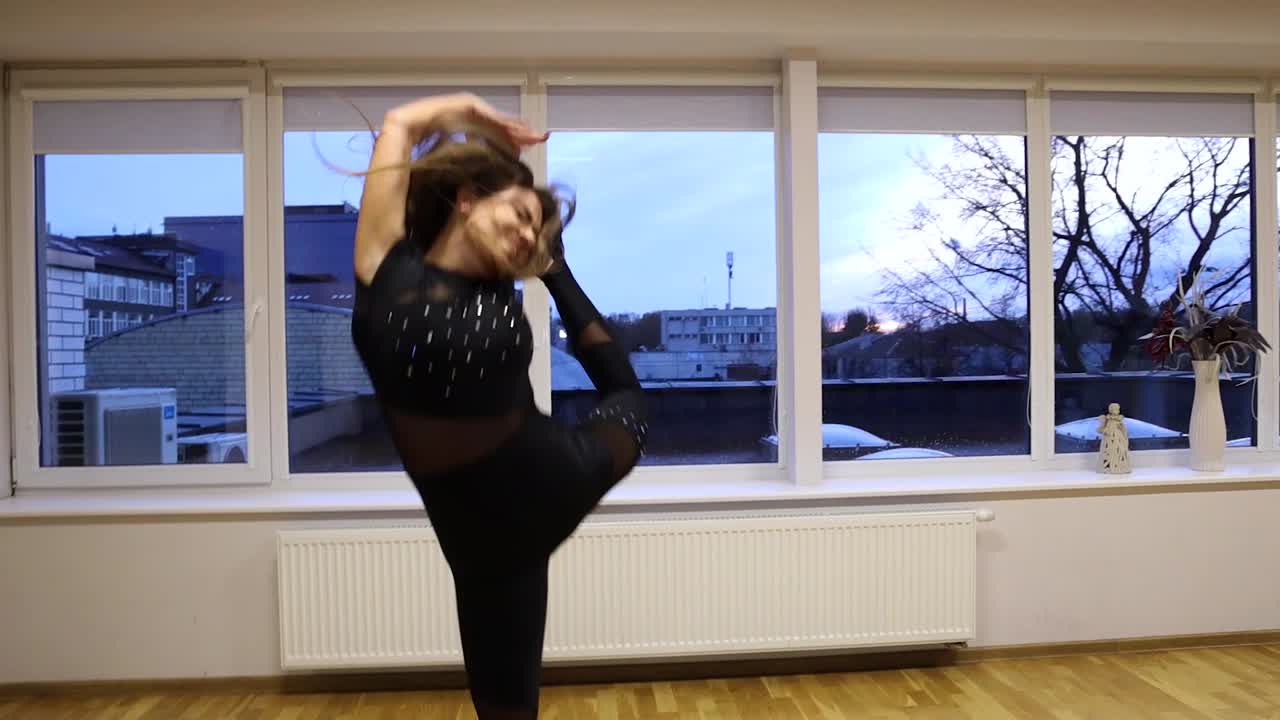 전문적이고 열정적인 여성 댄서가 댄스 플로어 슬로우 모션에서 춤을 춥니다