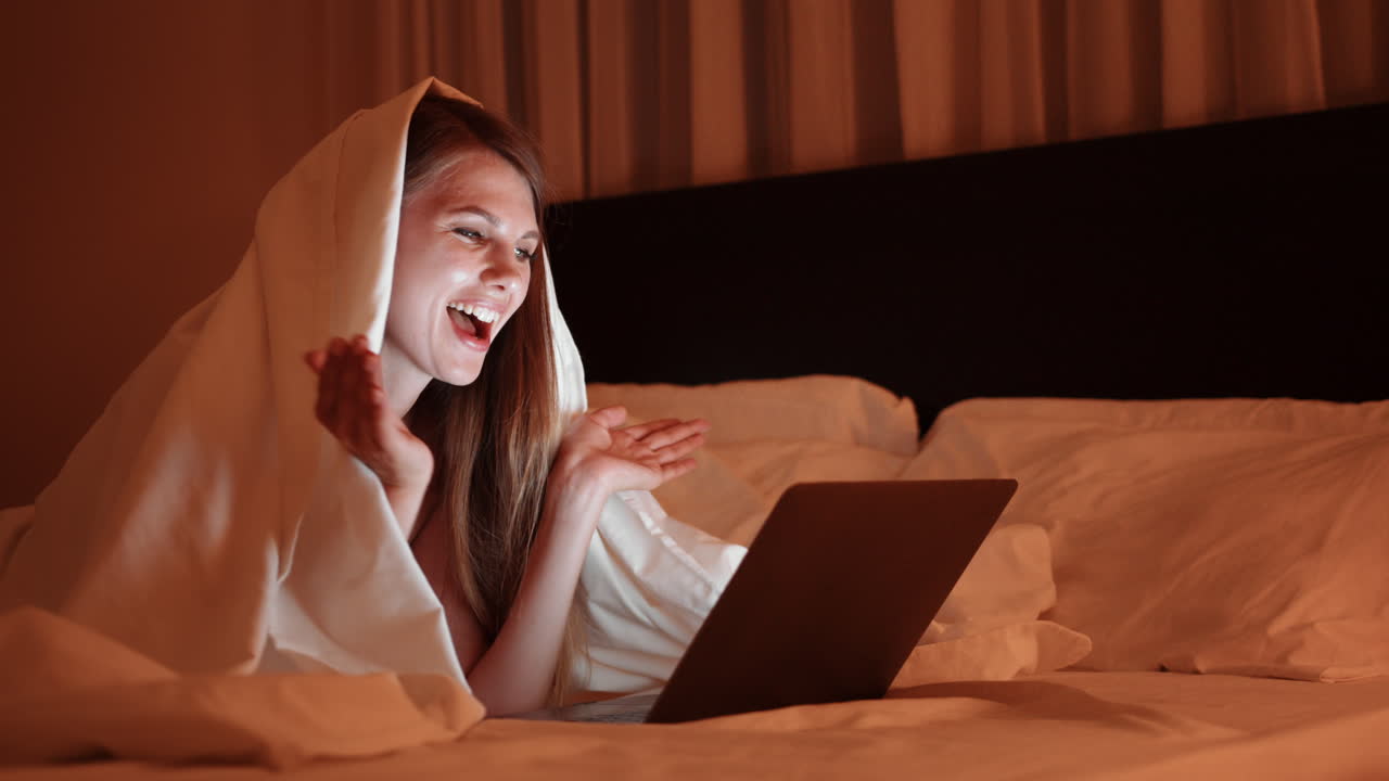 mujer viendo la computadora portátil en la cama por la noche