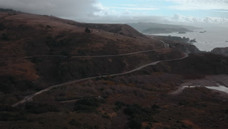 Scenic-drone-view-of-Highway-1-in-northern-California-with-coast-and-clouds-in-the-background