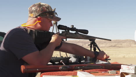 Cazador-En-El-Rango-Del-Desierto-Al-Aire-Libre,-Ajustando-El-Bípode-Del-Rifle-R25,-Tiro-Deslizante