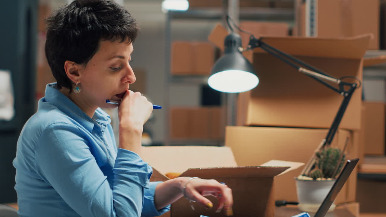Woman working in office surrounded by boxes