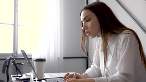 a woman is working with her laptop in an office 2