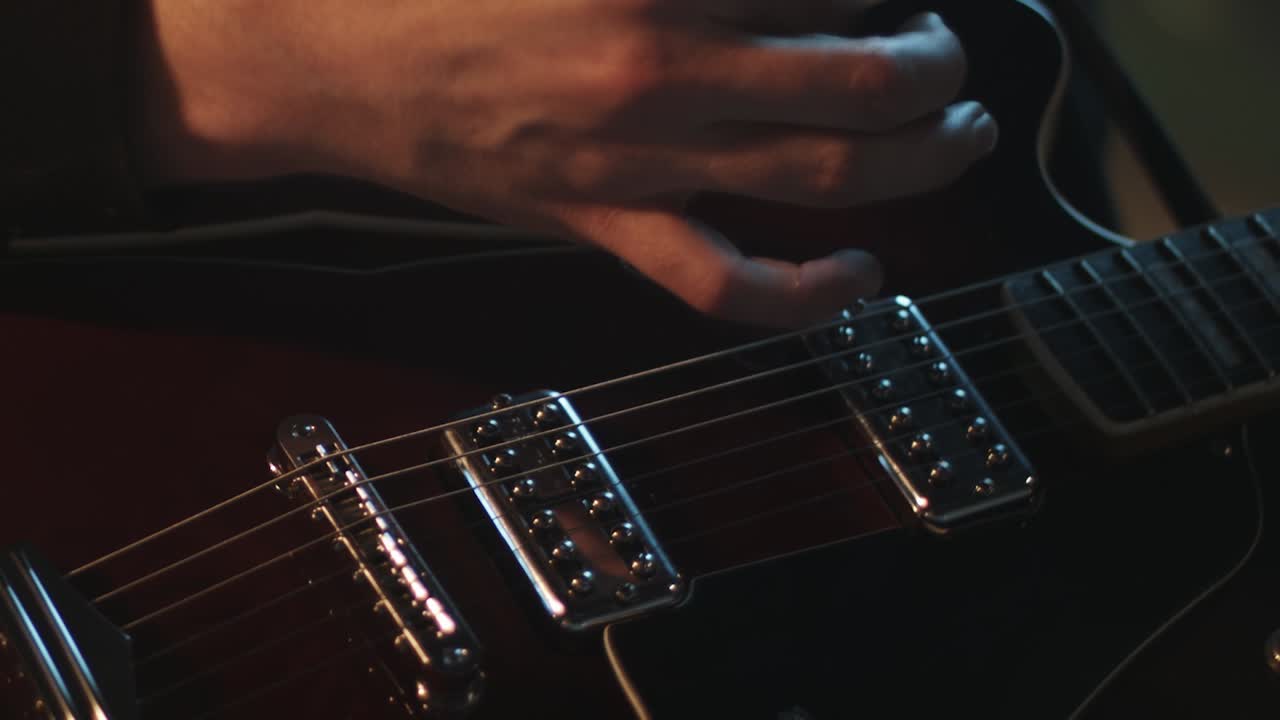 Intense electric guitar playing with flickering stage lights, capturing high energy