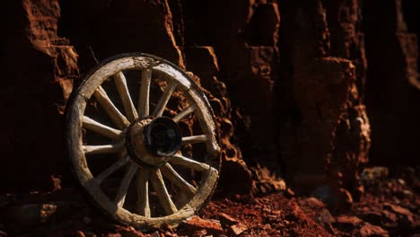 old wooden cart wheel on stone rocks