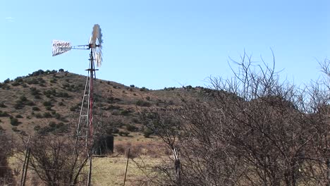 un viejo molino de viento gira en el desierto