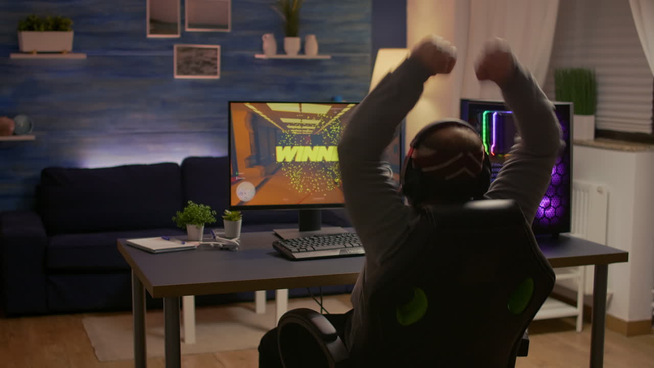 Videogamer player raising hands after winning