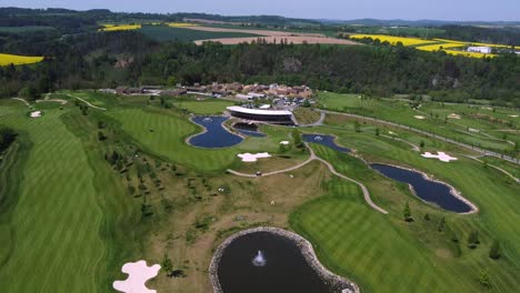 Golf-course-Kacov-in-Czech-Republic,-aerial-drone-view-of-green-course-and-pond