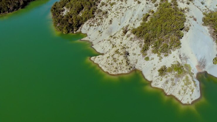 Costa delle montagne alpine bagnata da acque calme e limpide di un lago profondo, splendida destinazione per l'avventura nella natura