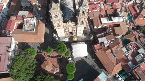 Top-view-of-the-park-and-the-catedral-at-Tasco-in-Mexico,-you-can-view-the-houses-and-the-architecture-around