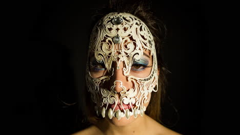 a woman with ornate venetian skull mask over face