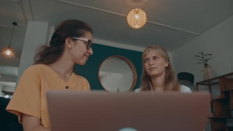 dos mujeres colaborando en una computadora portátil