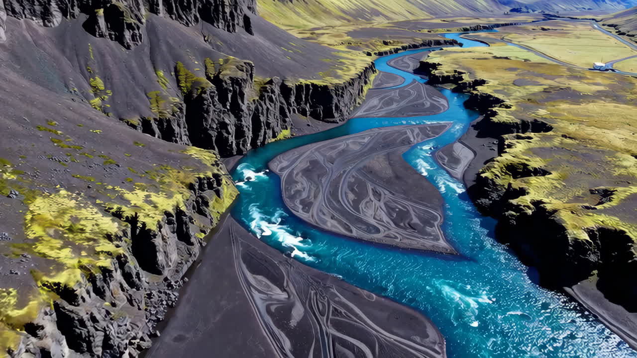 Aerial View of a Winding Blue River in a Dark Volcanic Landscape