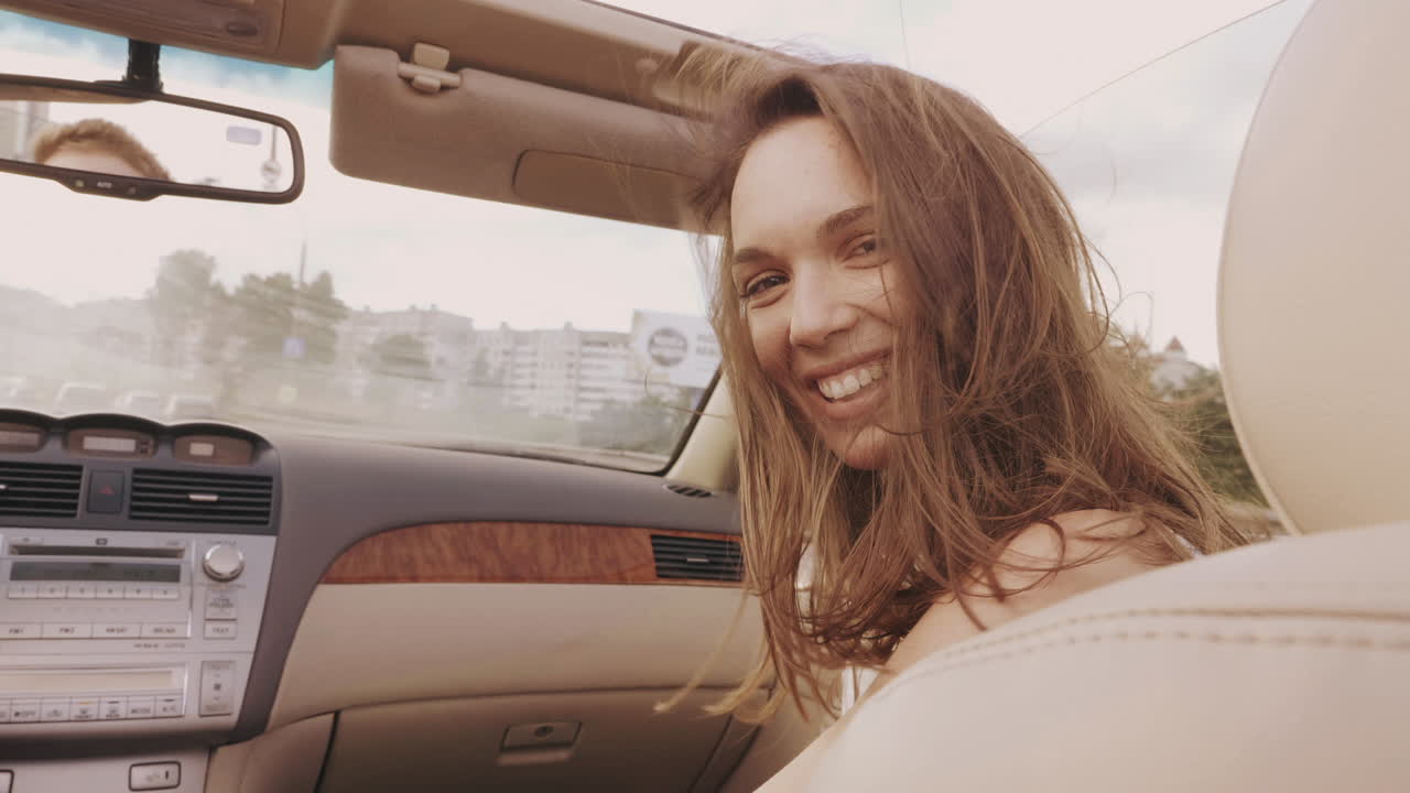 mujer feliz conduciendo un descapotable