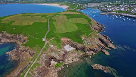 high drone shot flying over kermorvan peninsula, fort, rocky cliffs, and the old harbor with blue sea - brittany in france