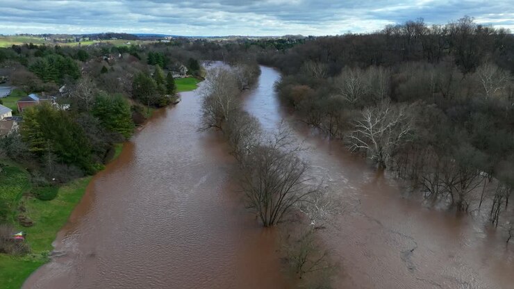 Vista aerea di un fiume in piena con acqua sporca dopo forti piogge in una periferia degli Stati Uniti