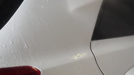 slow-motion close-up shot of pressure washing of a white car