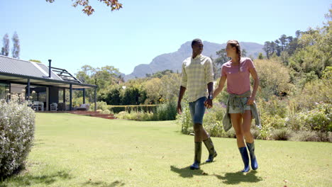walking together in garden, diverse couple enjoying nature and conversation in countryside, copy spa
