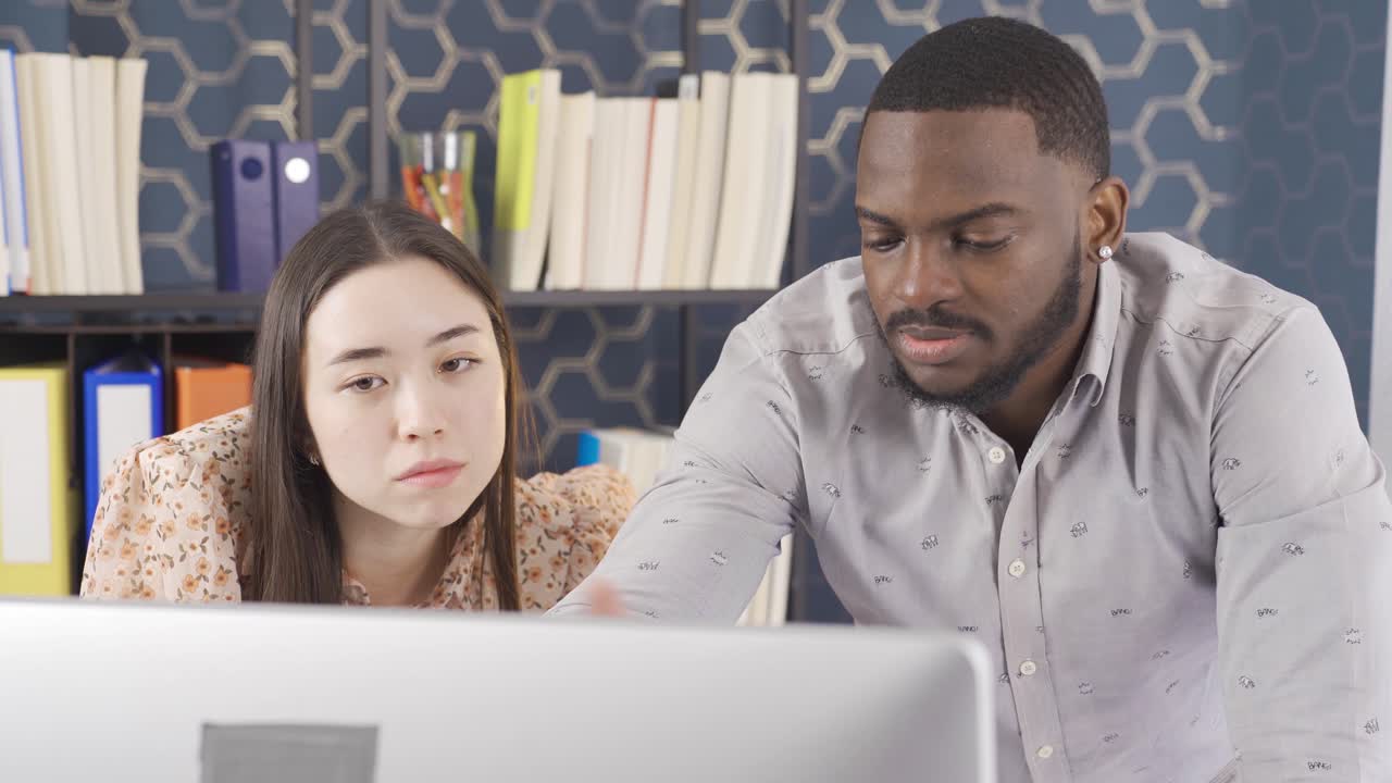 Multiethnic office workers working at computer.