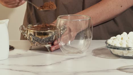 hot chocolate with marshmallow close up on marble background. woman preparing hot chocolate with marshmallow, close up accelerated video, loop