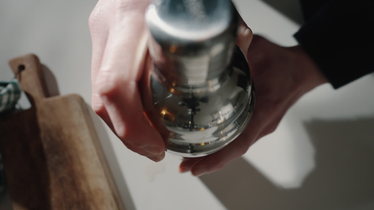 Barman che chiude lo shaker per cocktail in cucina, inquadratura dall'alto 4K.