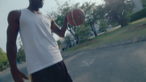 young black basketball athlete dribbling a ball on the road